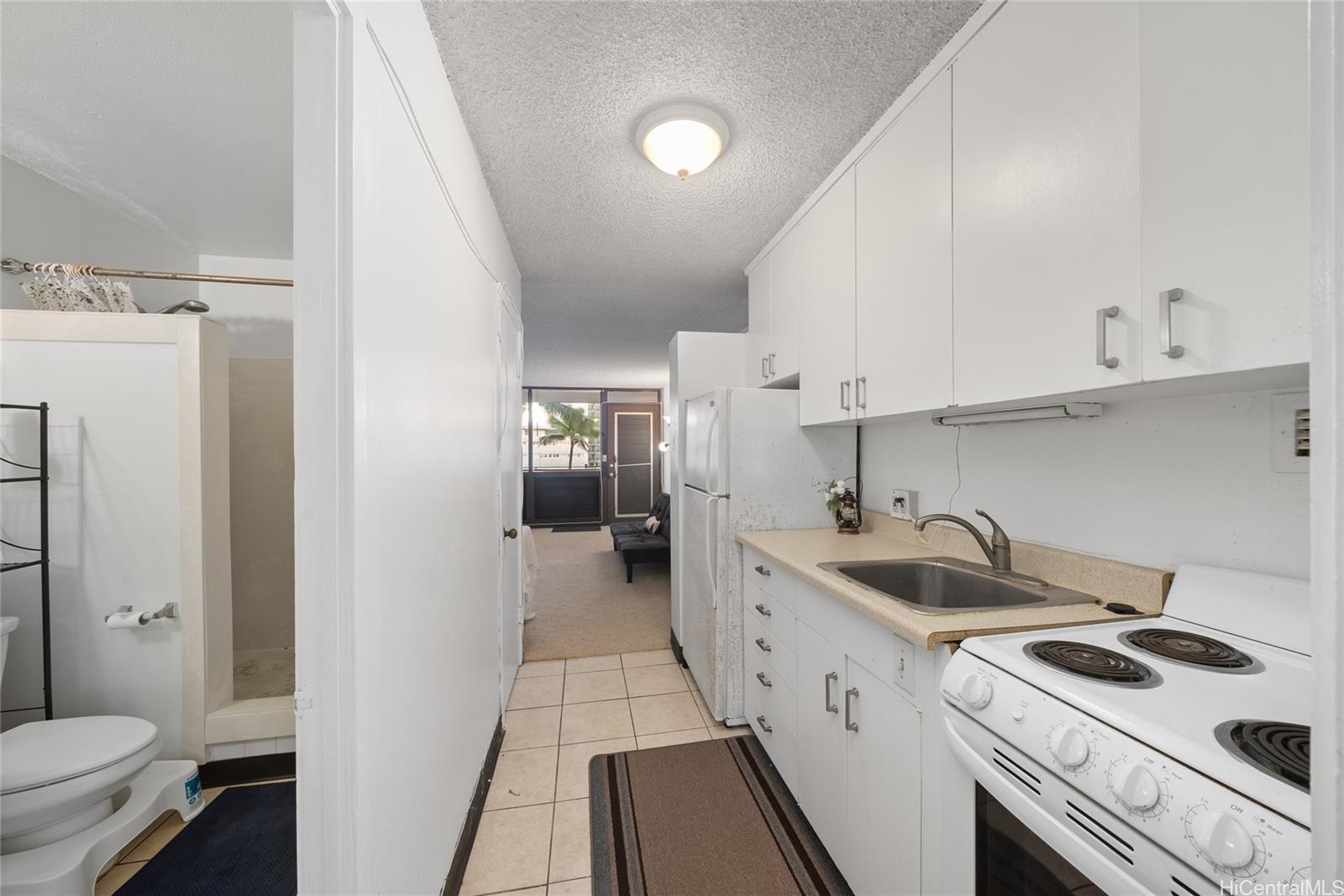 425 Ena Road, Unit B602 Honolulu, HI 96815 - Photo 3 of 16 a kitchen with white cabinets and white appliances