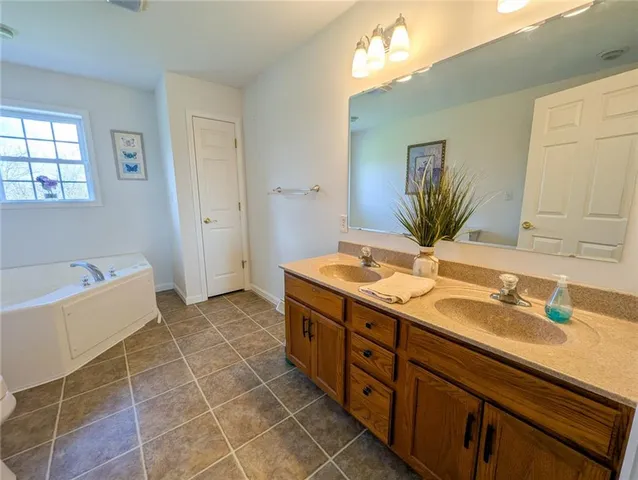 a spacious bathroom with a granite countertop sink a toilet a mirror and bathtub