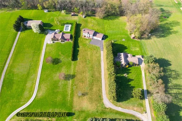 an aerial view of a residential houses with outdoor space and swimming pool