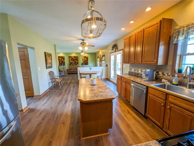 a kitchen with stainless steel appliances granite countertop a sink stove and refrigerator
