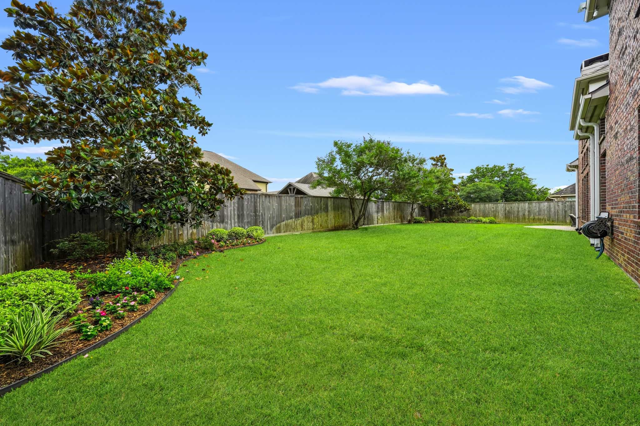 17610 Strackfield Lane Tomball, TX 77377 - Photo 48 of 50 A beautifully maintained backyard retreat awaits, complete with mature trees, sweeping lawn space, and plenty of room for pets to roam.