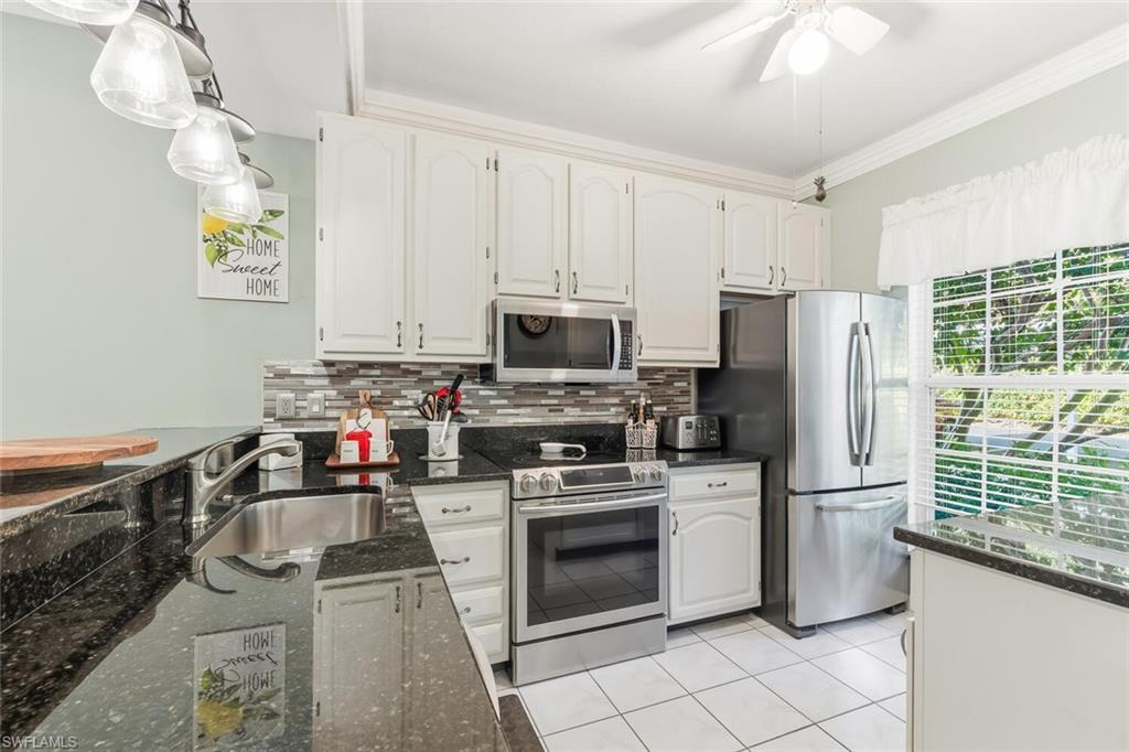 Undisclosed Address Naples, FL 34113 - Photo 5 of 24 a kitchen with a stove a sink and a refrigerator
