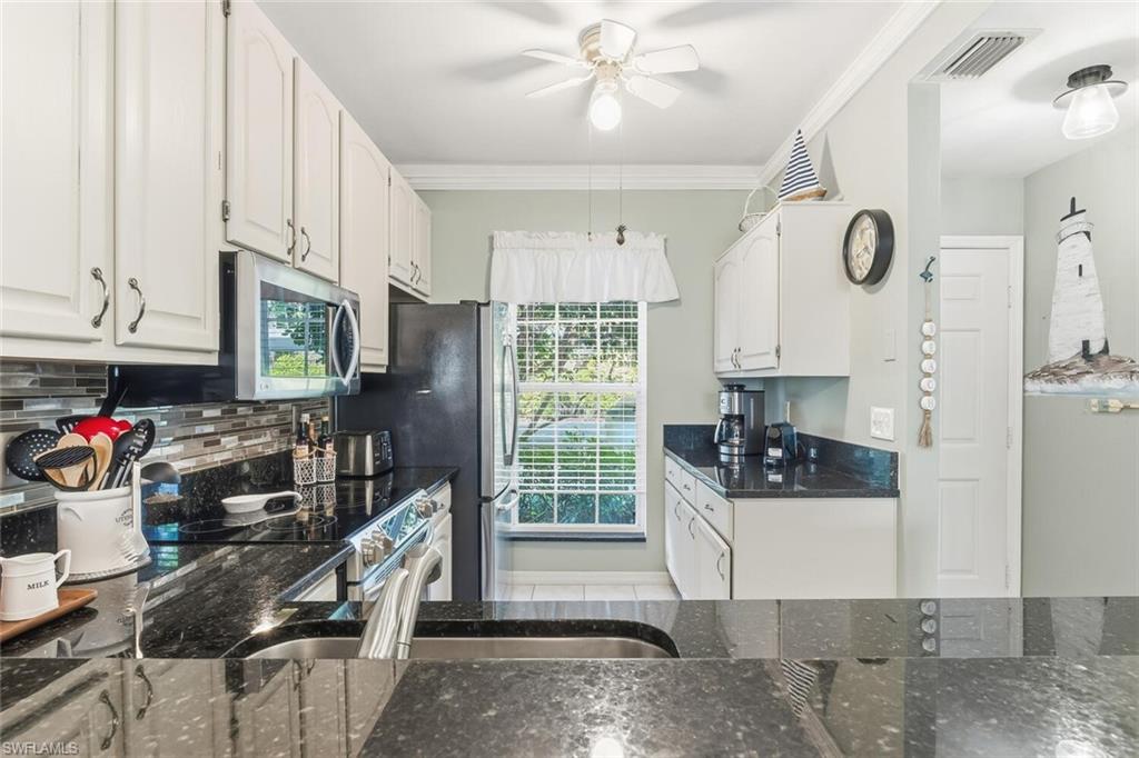 Undisclosed Address Naples, FL 34113 - Photo 6 of 24 a kitchen with stainless steel appliances granite countertop a stove and a refrigerator