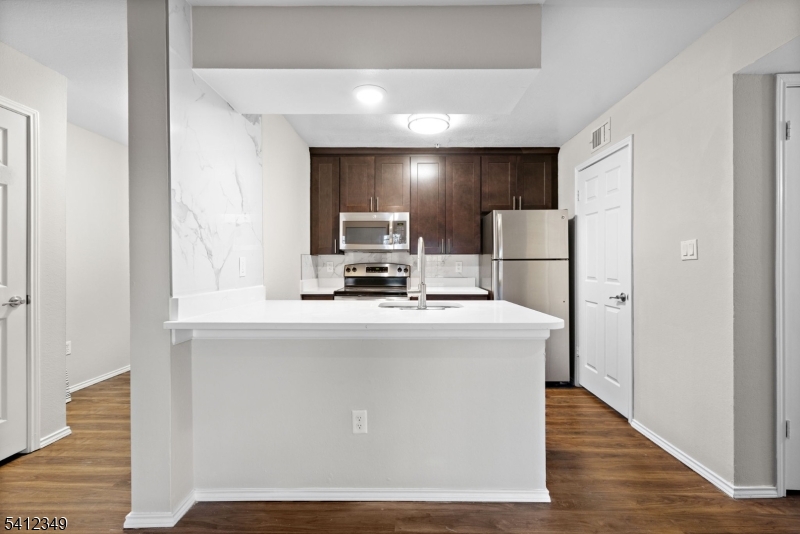 690 Route 23 Wayne Nj 07470, Unit R2 Wayne, NJ 07470 - Photo 4 of 9 a view of kitchen with stainless steel appliances wooden floor dining table and chairs