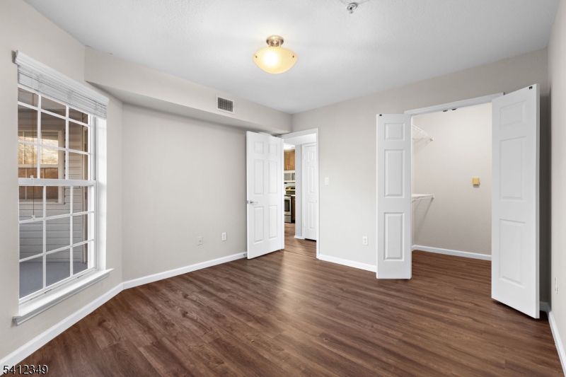 690 Route 23 Wayne Nj 07470, Unit R2 Wayne, NJ 07470 - Photo 6 of 9 a view of an empty room with wooden floor and a window