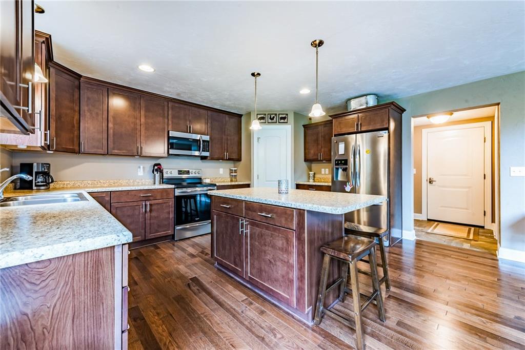 216 Saylor Road Dunbar, PA 15431 - Photo 11 of 25 a kitchen with stainless steel appliances granite countertop wooden cabinets a sink a stove a dining table and chairs