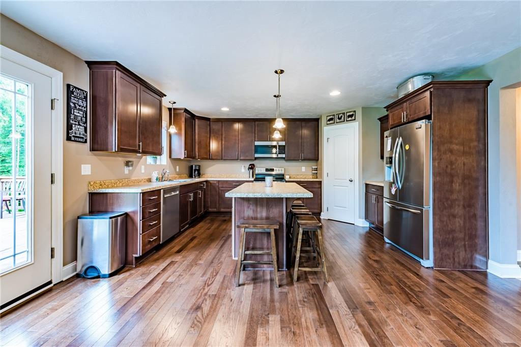 216 Saylor Road Dunbar, PA 15431 - Photo 12 of 25 a kitchen with a refrigerator a microwave oven a sink with wooden floor and cabinets