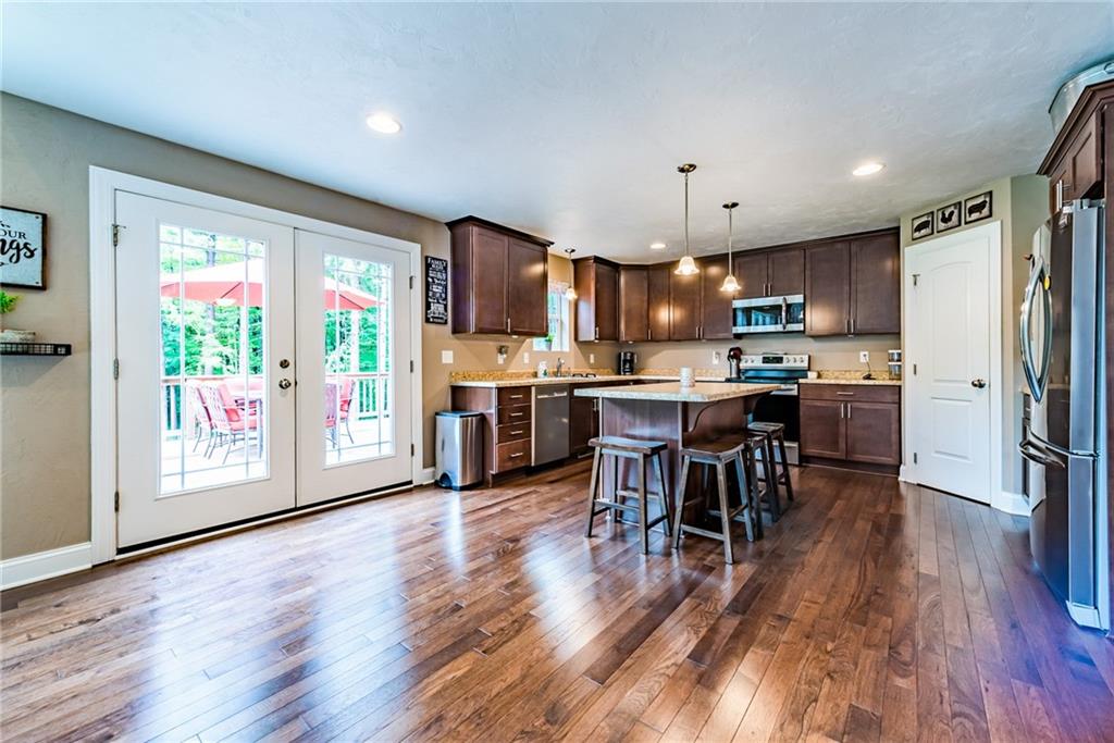 216 Saylor Road Dunbar, PA 15431 - Photo 10 of 25 a open kitchen with stainless steel appliances granite countertop a stove top oven a refrigerator a dining table and chairs with wooden floor