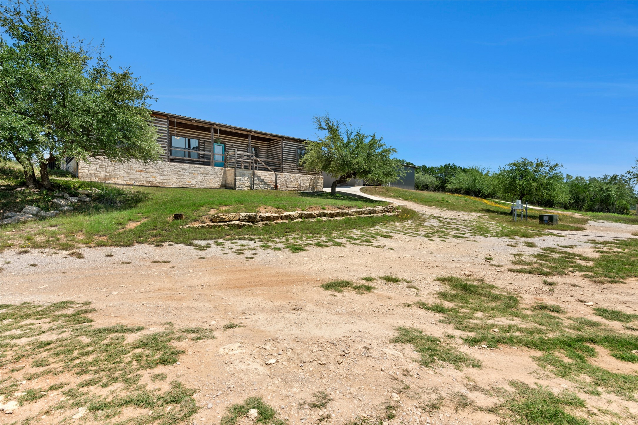 496 Middleton Road Spicewood, TX 78669 - Photo 34 of 40 Ranch-style residence featuring a prominent log cabin facade and stone foundational skirting