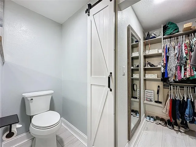 a bathroom with a granite countertop sink a toilet and a mirror