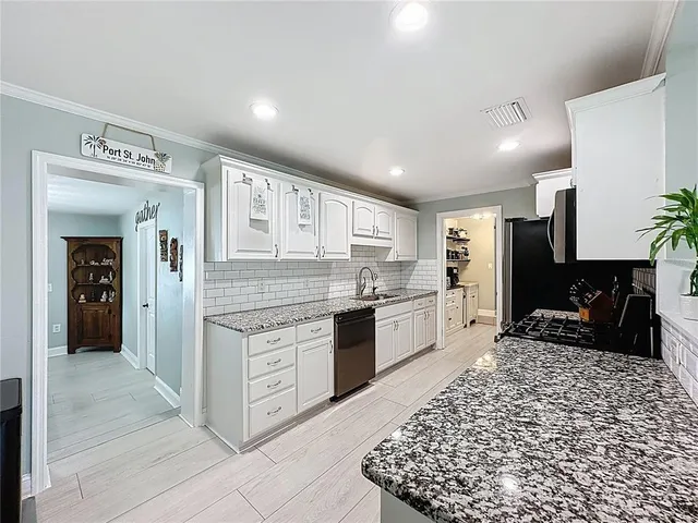 a kitchen with stainless steel appliances granite countertop a refrigerator and a stove