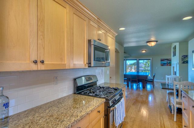 a kitchen with stainless steel appliances granite countertop a stove a sink and a microwave