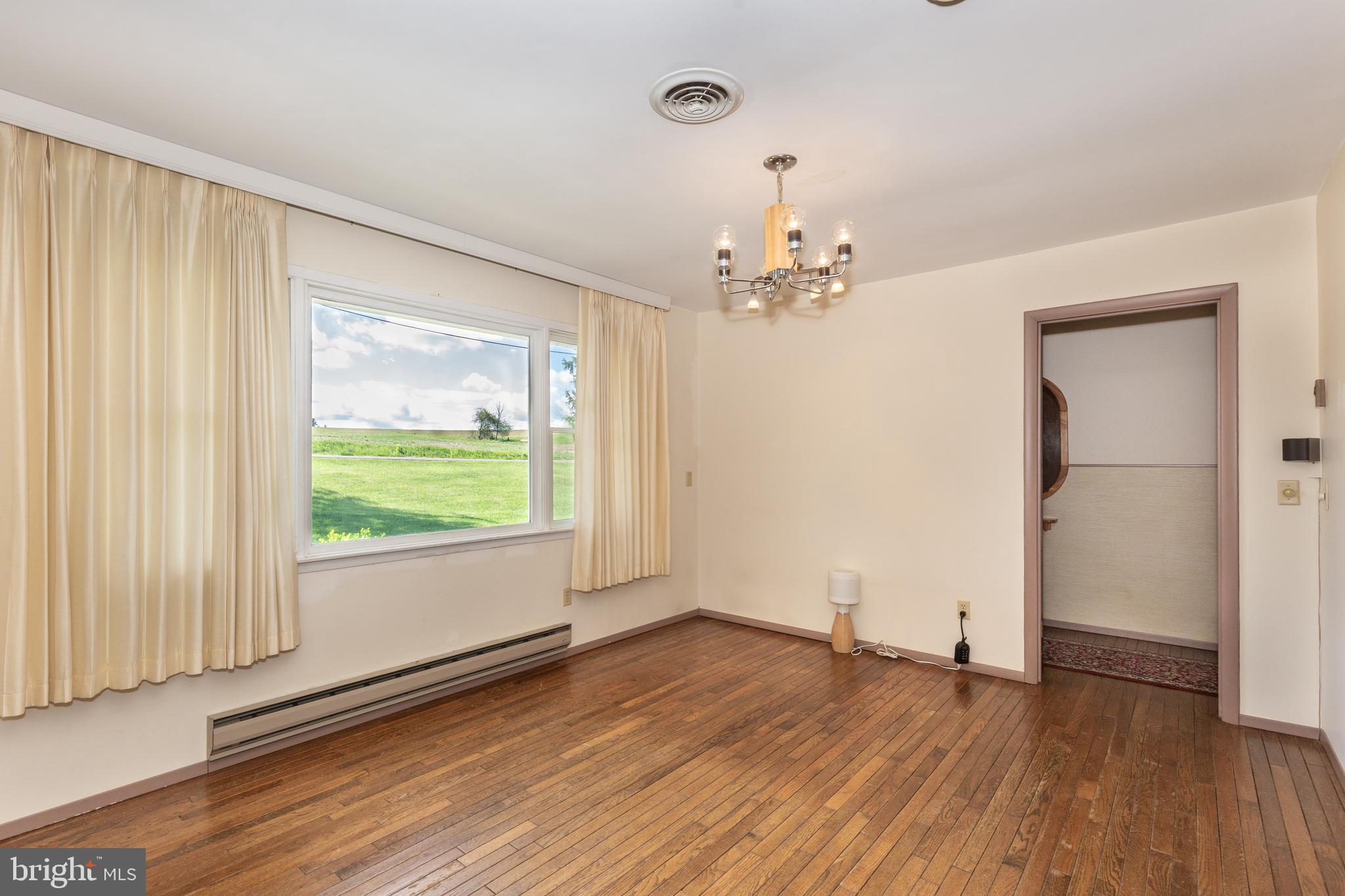 4300 Maple Grove Road Hampstead, MD 21074 - Photo 4 of 58 an empty room with wooden floor and windows