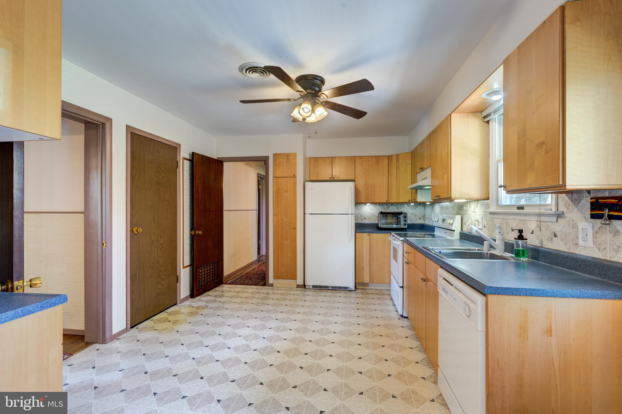 4300 Maple Grove Road Hampstead, MD 21074 - Photo 10 of 58 a kitchen with stainless steel appliances granite countertop a refrigerator a sink dishwasher a stove with white cabinets and wooden floor