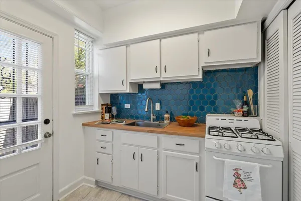 a kitchen with white cabinets and white appliances