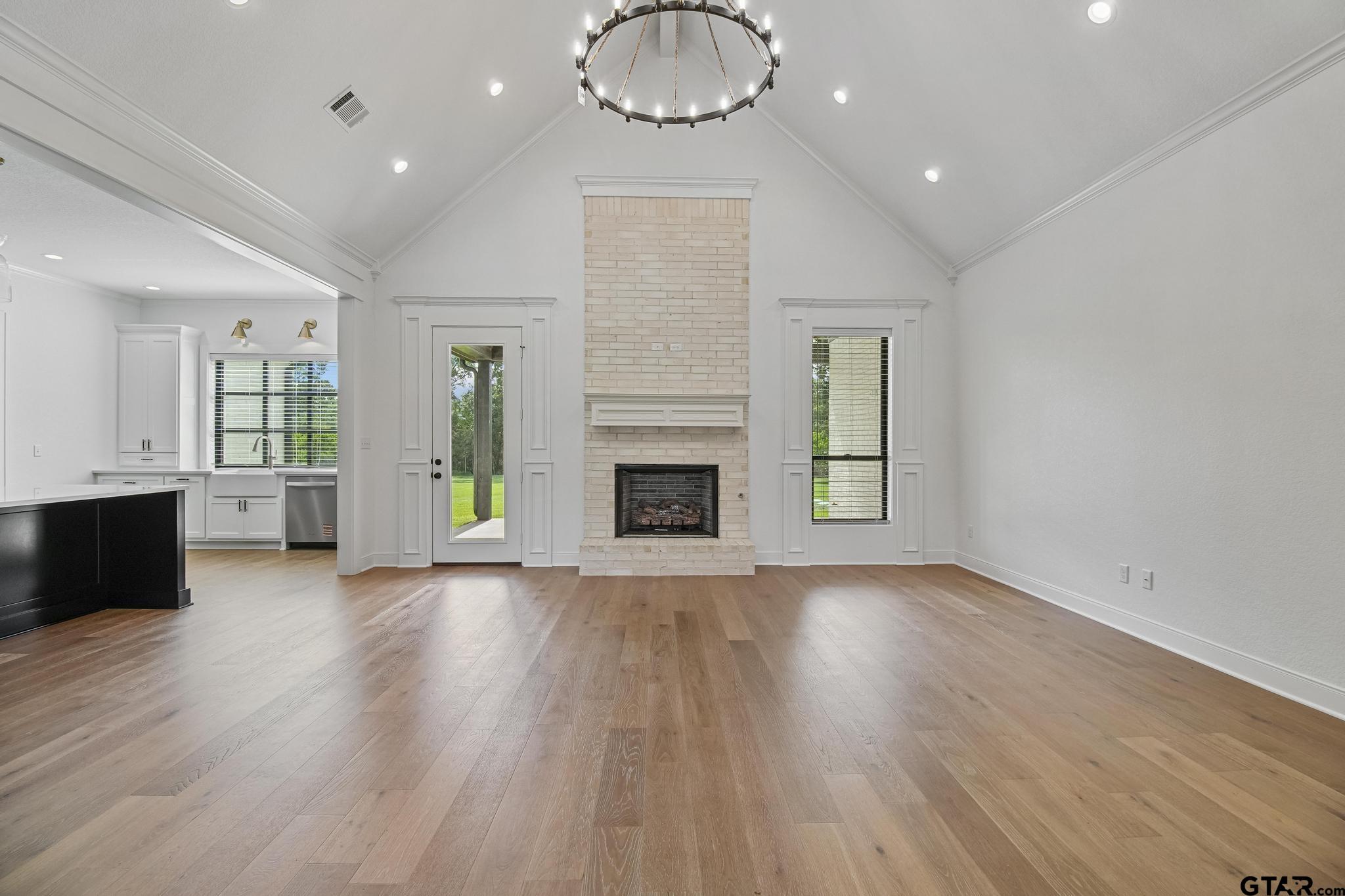 16511 Cooper Way Flint, TX 75762 - Photo 9 of 44 an empty room with wooden floor fireplace and windows