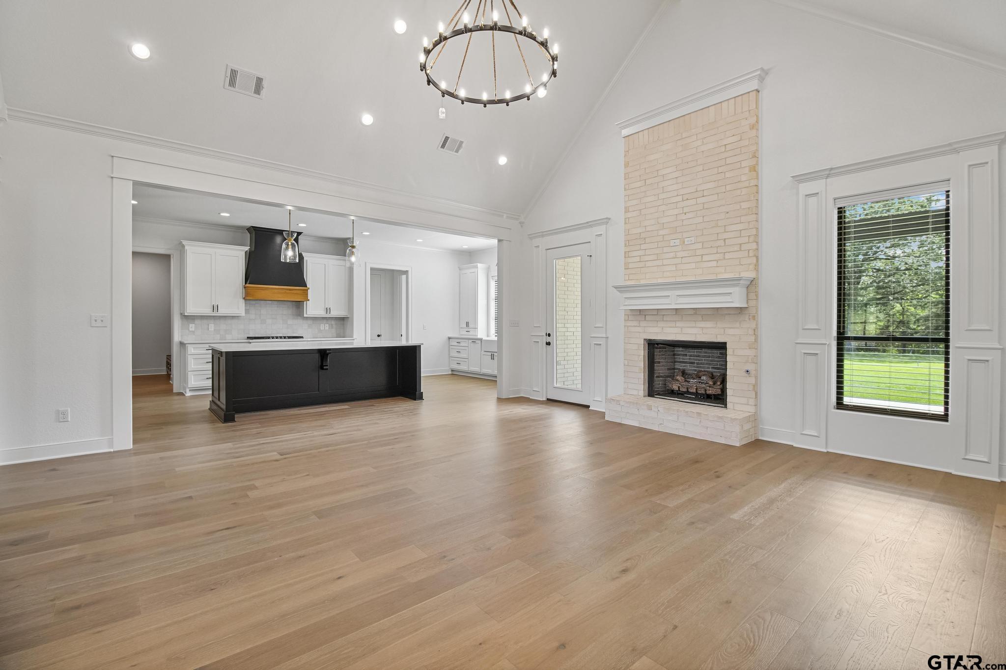 16511 Cooper Way Flint, TX 75762 - Photo 10 of 44 an empty room with wooden floor fireplace and windows