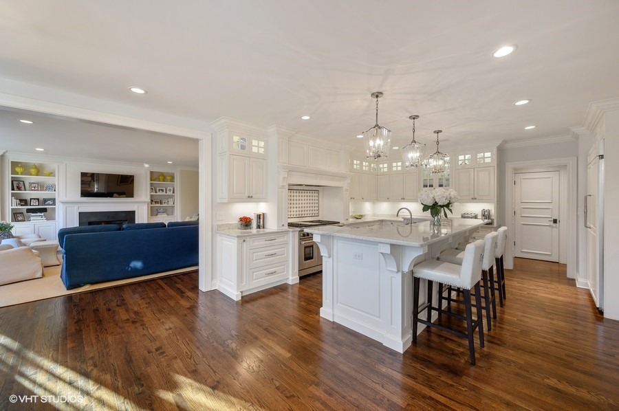29 Woodley Road Winnetka, IL 60093 - Photo 29 of 65 a kitchen with stainless steel appliances kitchen island granite countertop a stove top oven a sink dishwasher a dining table and chairs with wooden floor