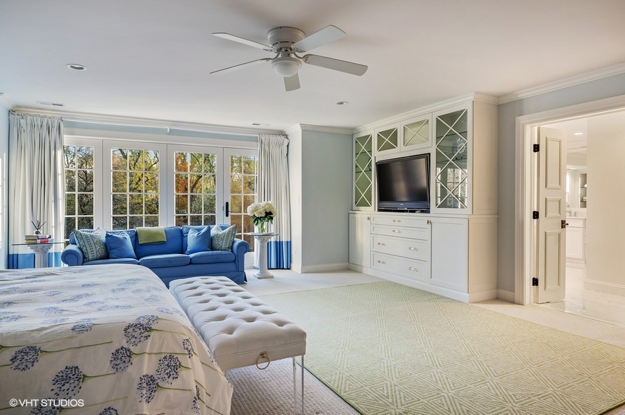 29 Woodley Road Winnetka, IL 60093 - Photo 41 of 65 a bedroom with a large bed a flat screen tv and a couch