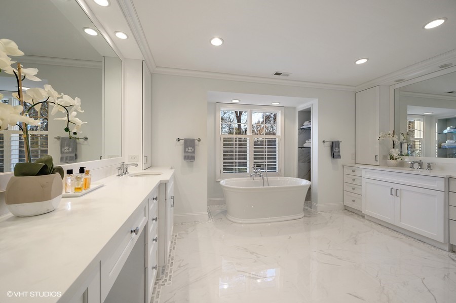 29 Woodley Road Winnetka, IL 60093 - Photo 43 of 65 a spacious bathroom with a double vanity sink a large mirror and a bathtub