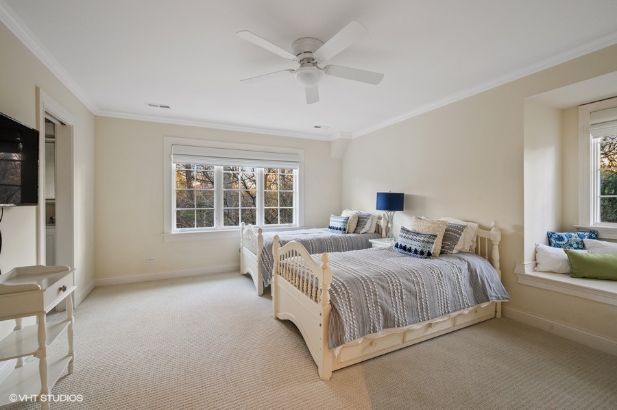 29 Woodley Road Winnetka, IL 60093 - Photo 53 of 65 a bedroom with a bed a window and a ceiling fan