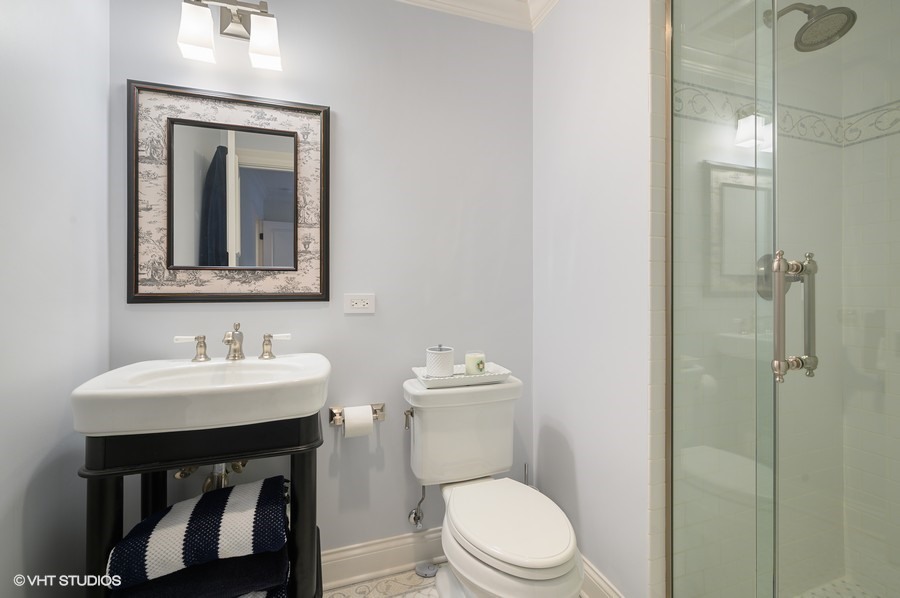 29 Woodley Road Winnetka, IL 60093 - Photo 55 of 65 a bathroom with a toilet a sink and mirror
