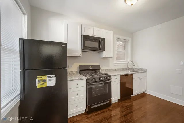 a kitchen with stainless steel appliances a stove microwave and sink
