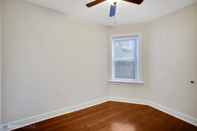 an empty room with a window and wooden floor