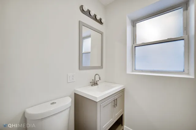 a bathroom with a toilet sink and mirror