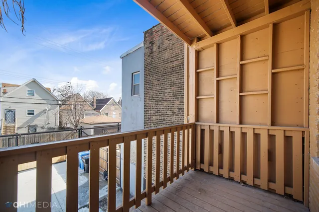 a view of a balcony with wooden floor and fence