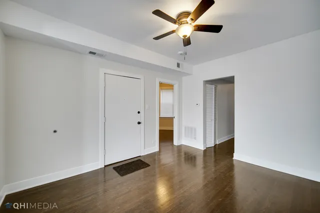 a view of an empty room with wooden floor