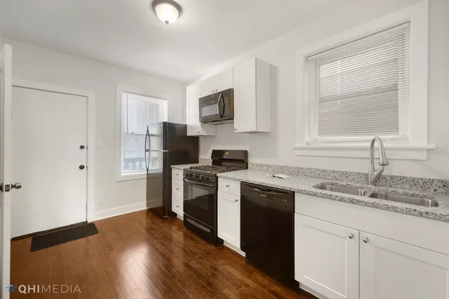 a kitchen with granite countertop a sink cabinets and stainless steel appliances