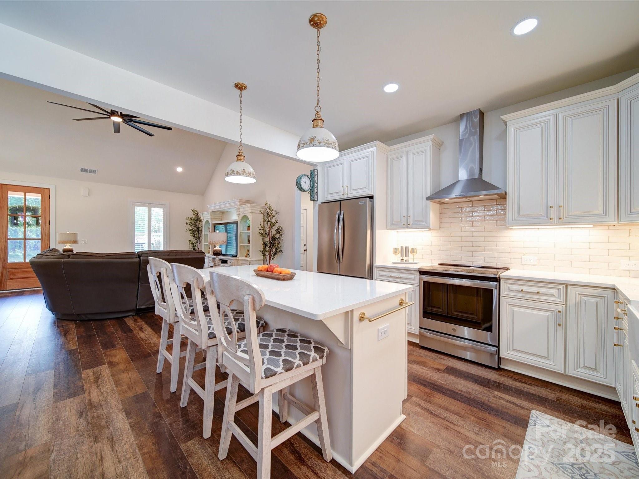 1026 Trull Hinson Road, Unit 4 Wingate, NC 28174 - Photo 10 of 14 a kitchen with stainless steel appliances kitchen island granite countertop a stove a sink a refrigerator and a dining table with wooden floor