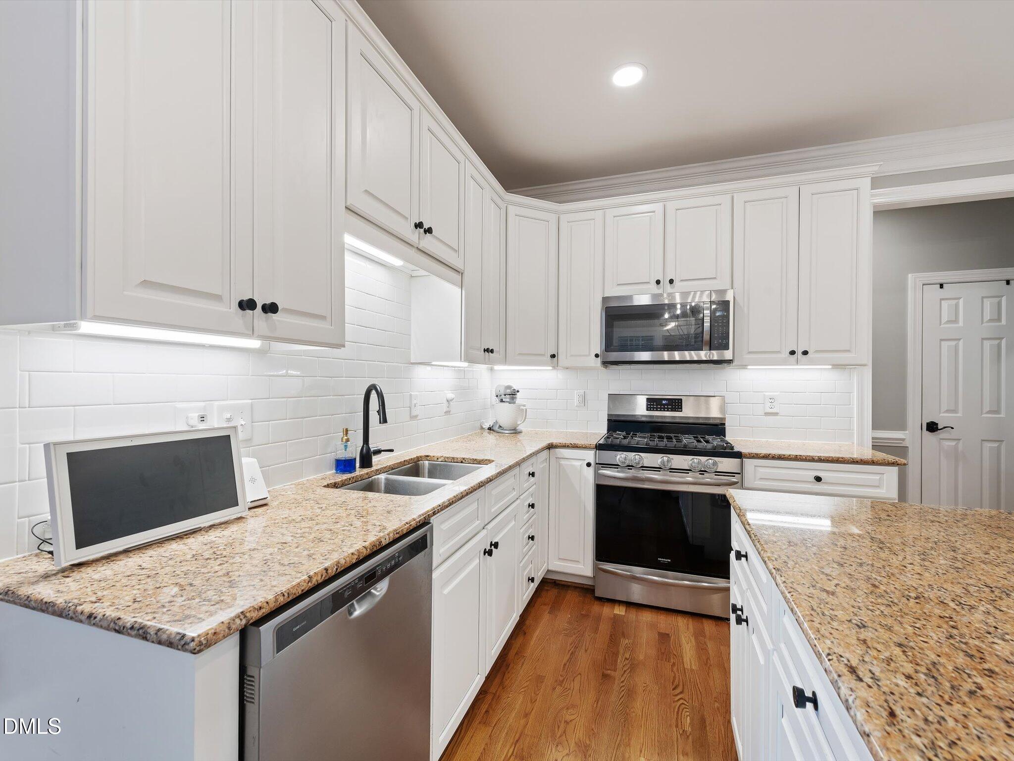 4201 Falls River Avenue Raleigh, NC 27614 - Photo 19 of 52 a kitchen with stainless steel appliances granite countertop a stove sink and cabinets