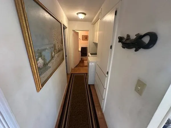 a view of a hallway with wooden floor and stairs