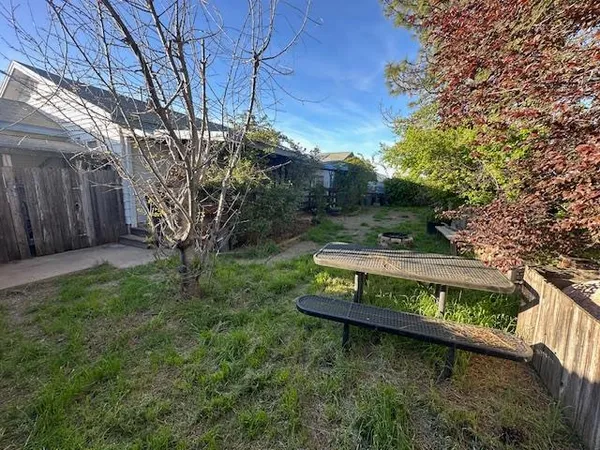 a view of a yard with wooden fence