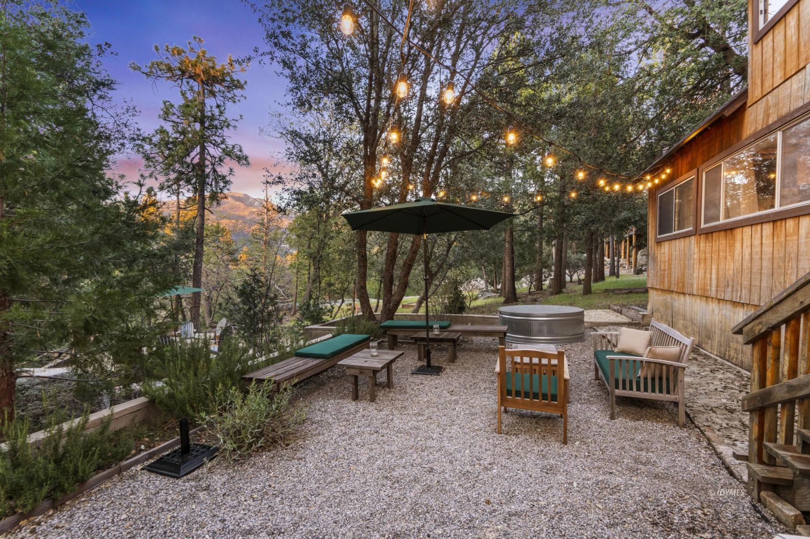 53241 Middleridge Drive Idyllwild, CA 92549 - Photo 36 of 48 a view of a patio with table and chairs under an umbrella