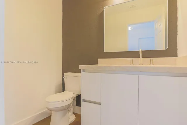 a bathroom with a sink a toilet and mirror