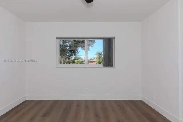 a view of a small space with wooden floor and a window
