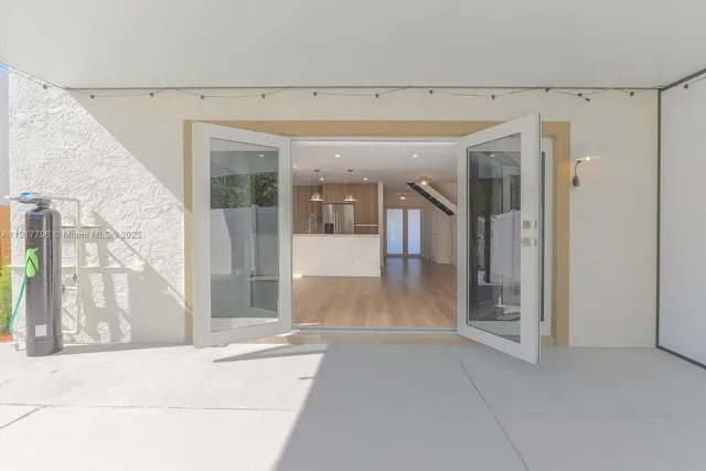 a view of a hallway with wooden floor and a living room