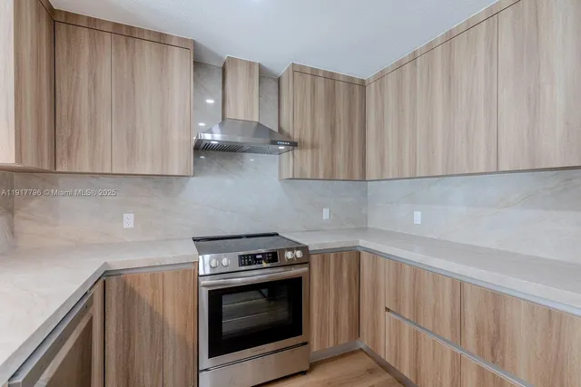 a kitchen with granite countertop white cabinets and stainless steel appliances