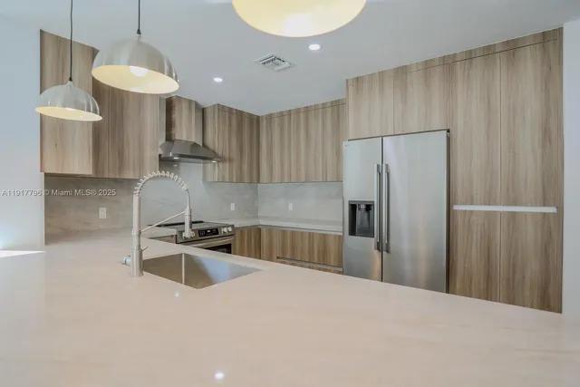 a kitchen with stainless steel appliances a refrigerator sink and stove