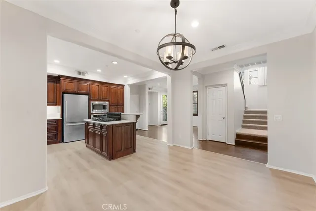 a large kitchen with a table and stainless steel appliances