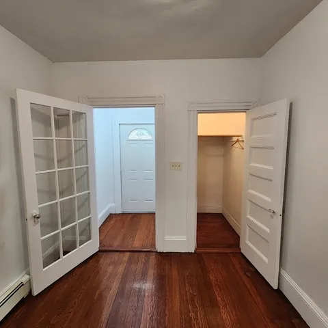 an empty room with wooden floor and a window