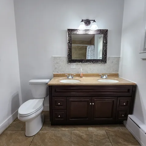 a bathroom with a toilet sink and mirror