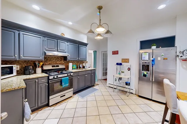 a kitchen with stainless steel appliances granite countertop a refrigerator a stove a sink dishwasher and a refrigerator with wooden floor