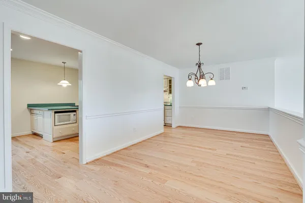 a view of a room with wooden floor staircase and a kitchen space