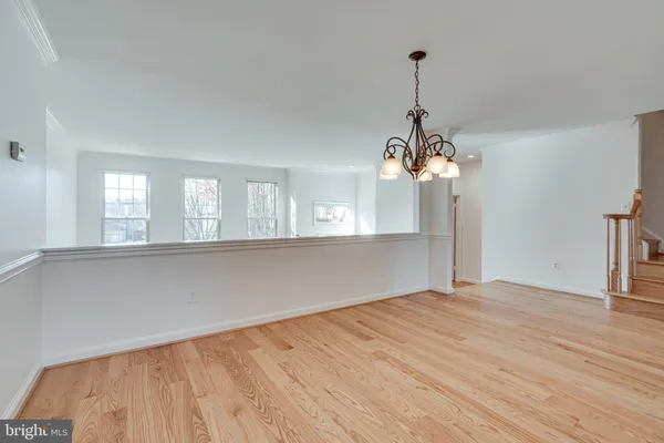 a view of a room with wooden floor and chandelier