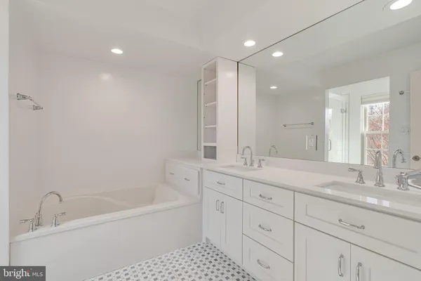 a bathroom with a tub sink and mirror