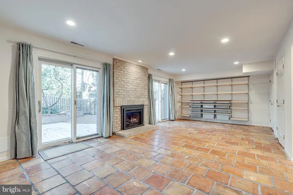 a view of an empty room with a fireplace and a window